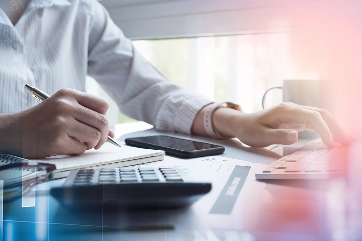 Zwei Hände arbeiten auf der Tastatur und schreiben eine Notiz